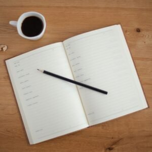 Notebook and coffee on a desk, cover image for the Move-Out & Move-In Service Transfer Planner PDF